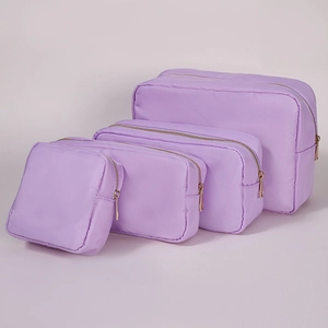 Detail of four purple nylon cosmetic bags in various sizes with premium gold zippers