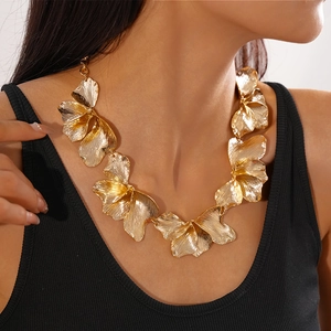 Detail of metallic golden petal necklace showcasing textured layers on neck model