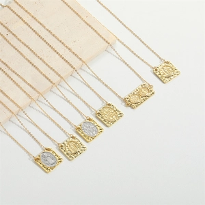 Macro shot of vintage rectangular religious pendants with embossed icons on marble
