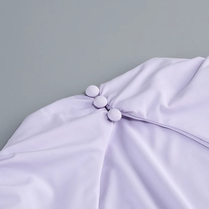 Detail of light purple twill fabric with three matching fabric-covered buttons on a dress