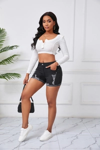Detail der High-Waist-Jeans-Shorts mit Distressed-Saum und weißem Langarm-Crop-Top