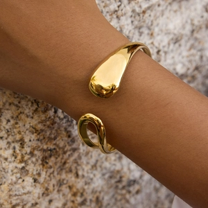 Detailed view of teardrop gold plated stainless steel cuff bracelet with polished finish
