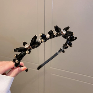 Detailed view of handcrafted black faceted beads and rhinestone flower accents on a headband
