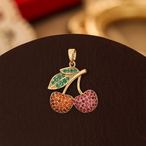 Exquisite cherry pendant with green leaf and colorful crystals on leather surface