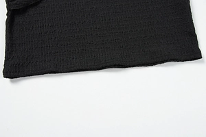 Gros plan sur le tissu en maille plissé noir extensible montrant la texture et l'élasticité