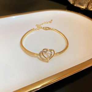 Close-up of interlocking double heart bracelet with clear pavé zircon and gold plating
