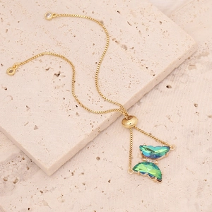 Detail of 18K gold-plated butterfly bracelet with gradient green and blue crystals