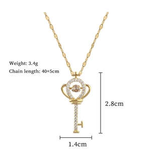 Detailed view of gold key pendant with sparkling stones and size specifications