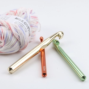 Macro detail of 10.0mm aluminum crochet hook with colorful milk cotton yarn on white background