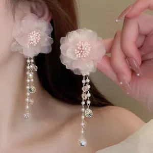 Ohrringe mit rosa Netzblumen, langen Perlenquasten und Kristallperlen an einem Modell
