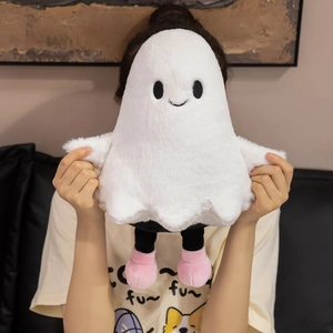 Close-up of a soft white plush ghost doll with pink shoes held by a person