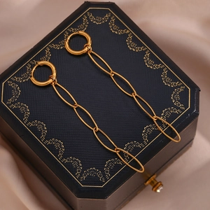 Macro detail of 18K gold-plated chain earrings on a blue jewelry box with silk background
