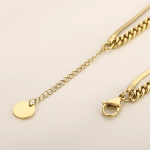 Vue macro de la chaînette d'extension dorée et du fermoir mousqueton du collier double