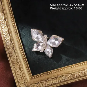 Close-up of crystal butterfly brooch on black velvet frame showing 3.7x2.4cm dimensions