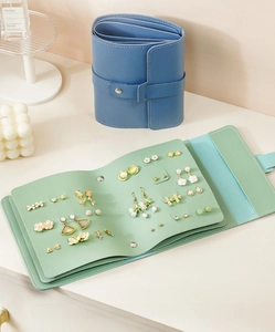 Detail of portable PU leather jewelry storage book in mint green and navy blue colors