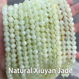Macro shot of natural green Xiuyu jade beads showing translucent texture and glossy finish