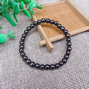 Pulsera elástica de cuentas de hematita para yoga y deporte sobre soporte de bambú