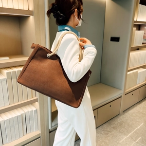 Detailed side view of a brown canvas tote bag with unique thick hemp rope handles