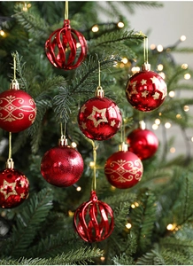 Close-up of red Christmas ball ornaments with glitter and star patterns on a tree