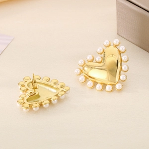 Detailed close-up of 18K gold-plated heart earrings with pearl inlay and metal backing