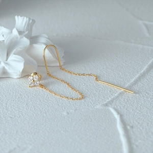 Detail of S925 sterling silver golden chain earrings with zircon flower tassels