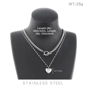 Double-layered stainless steel necklace featuring thick Cuban chain and heart pendant on mannequin