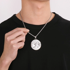 Close-up of a silver Tree of Life pendant necklace worn by a male model on a twist chain