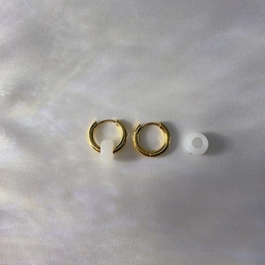 Detailed shot of 18k gold plated stainless steel hoops with white natural stone charms