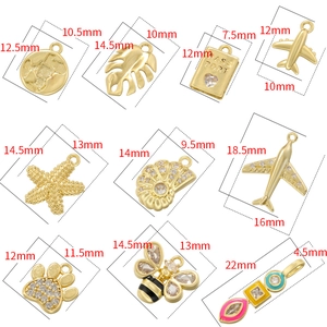 Assorted gold charms including globe, airplane, and shell with dimension measurements
