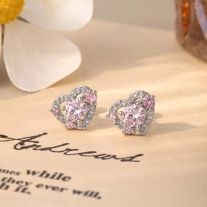 Silver stainless steel heart stud earrings with pink zircon on a floral background