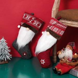 Nordic style gnome Christmas stockings in red and grey with snowflakes on wooden chair