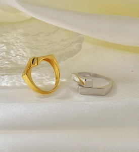 Detail of gold and silver S925 sterling silver geometric rings on white silk