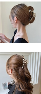 Detail of a black and white checkered acetate hair claw clip worn on a half-up hairstyle