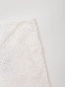 Detailed macro view showing intricate white lace embroidery and hollow floral textures