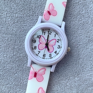 Detailed top view of white silicone kid watch with pink butterfly print on felt background