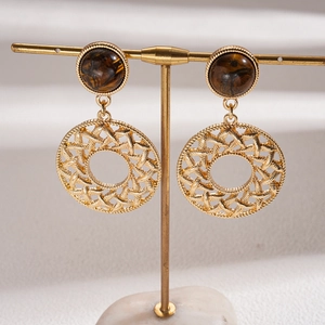 Detail of vintage tiger eye stone earrings with hollow gold mesh ring on jewelry stand