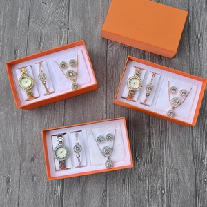 Close-up of five-piece quartz watch and jewelry set in an elegant orange gift box