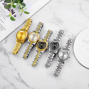 Luxury quartz watches set with diamond markers and steel bands on marble surface