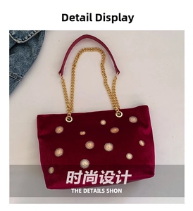 Detail of burgundy velvet tote with star rivets and gold chain handle shoulder strap