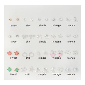 Lot de 25 paires de boucles d'oreilles assorties avec perles et cristaux sur fond blanc