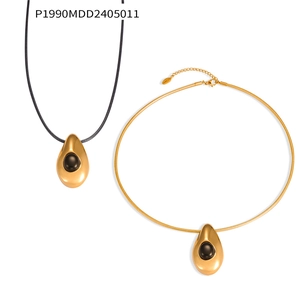Detail of gold water drop pendants with black agate on cord and metal choker