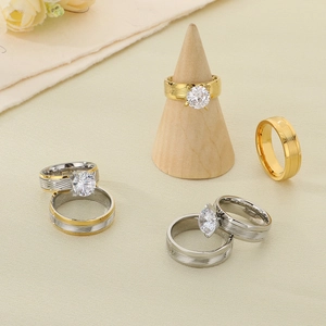 Detailed view of gold and silver couple rings with zircons on wooden cone stands
