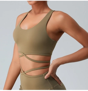 Detailed view of olive green sports bra with cross-strap waist design and elastic fabric