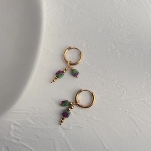 Detailed macro view of 18k gold plated titanium earrings with natural stone pendants
