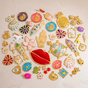 Macro of various 18K gold plated charms with colorful enamel and pearl details