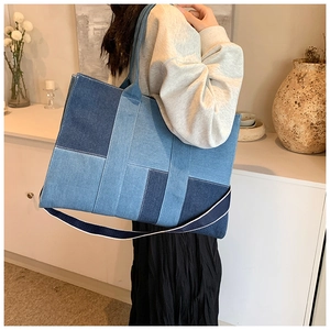 Detail view of large denim patchwork tote bag with blue geometric fabric blocks