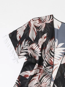 Détail d'un cache-maillot en mousseline à motif de palmiers tropicaux et franges blanches