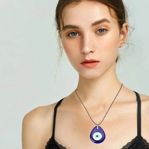 Détail du pendentif œil bleu en forme de larme sur un cordon noir porté