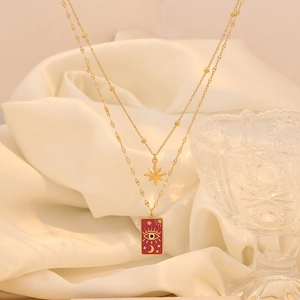 Detail view of double-layered gold necklace with celestial star moon and eye pendants