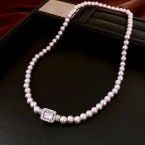 Vintage pearl necklace with a zircon rectangular pendant on a black leather display
